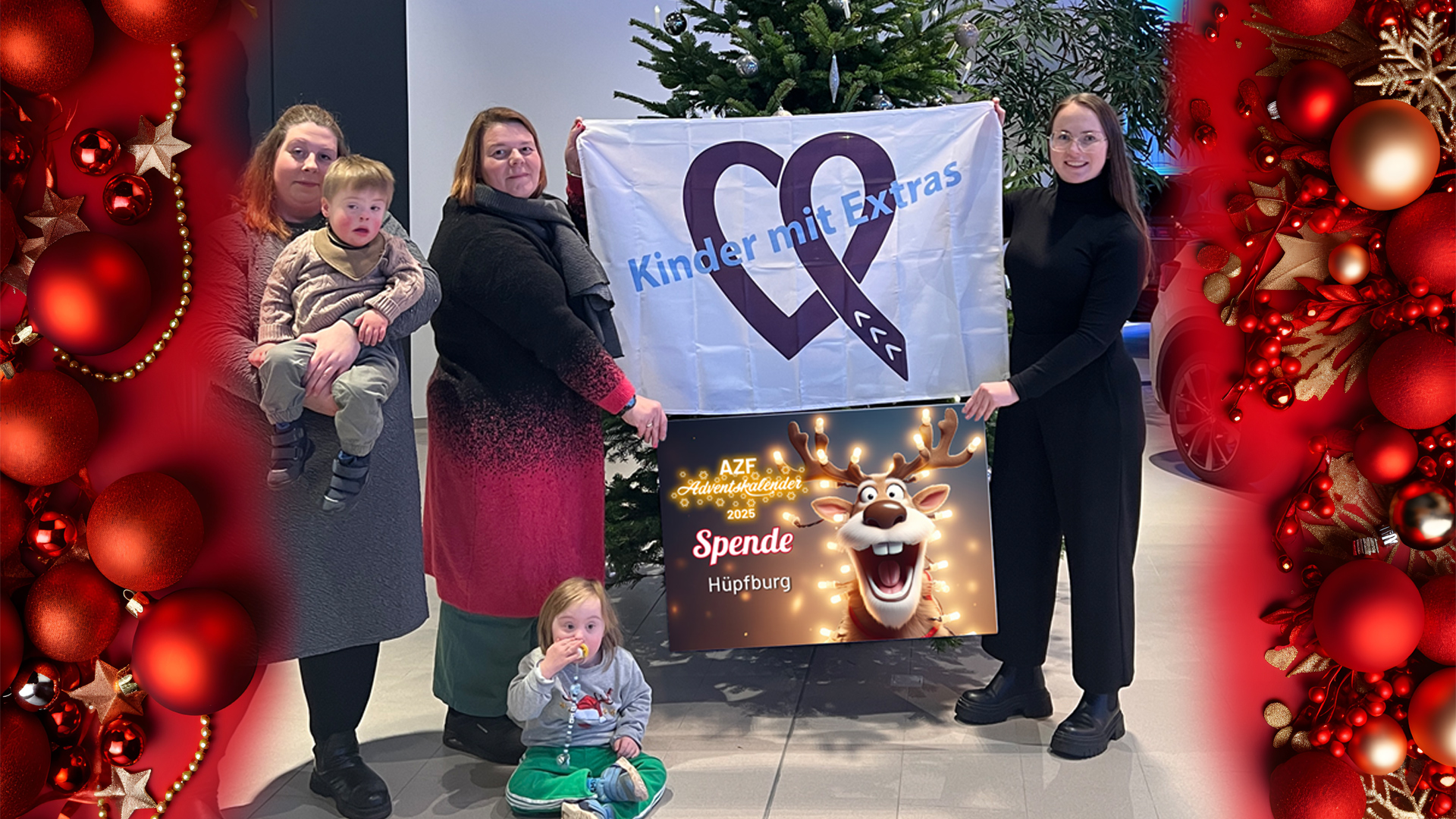 Drei Erwachsene Personen halten eine Spendentafel und eine Fahne, zwei Kinder mit Downsyndrom sind im Vordergrund zu sehen alle lachen in die Kamera